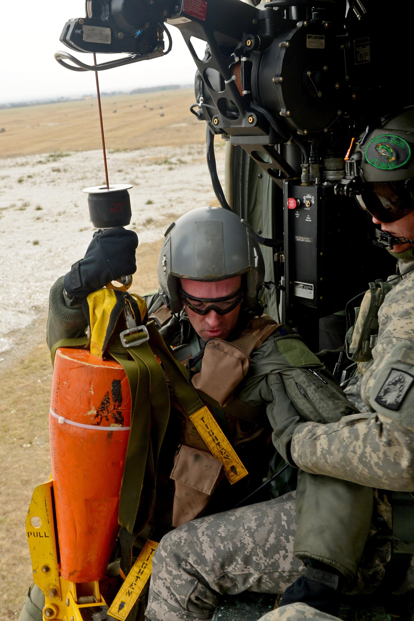 Lt. Col. Christopher Austin, (from left) is pulled onto a UH-60 Black Hawk helicopter by U.S. Army Sgt. Keith Dishman, 12th Combat Aviation Brigade crew chief during a joint-service combat search and rescue training mission, Jan. 28, 2014 at Cellina Meduna, Italy. After successfully evading opposing forces and communicating with assets in the air, isolated Airmen were extracted from “hostile” areas by the 12th CAB. (U.S. Air Force photo/Senior Airman Briana Jones) 

