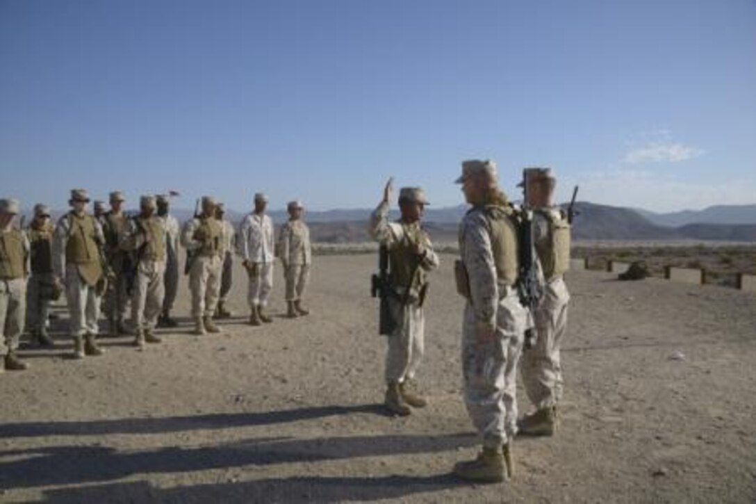 Corporal Samnorp Deung, supply clerk with Headquarters Battalion, Marine Corps Logistics Base Barstow, Calif., reenlists after a shooting range, August 20, 2013. Marines looking to reenlist this year will have a tougher time than in the past
