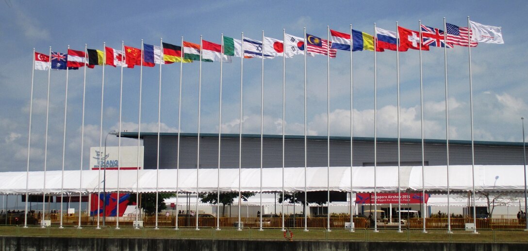 Flags of participating nations fly at Changi Air Base Feb. 13 during the Singapore International Airshow 2014. The U.S. is the feature country for this airshow. The Singapore Air Show 2014 helps build stronger relations between the U.S. and Singapore, as well as among the international community. The event promotes military to military discussions on aircraft and equipment, which enables greater interoperability of aviation platforms, and furthers international military relationships and cooperation. The U.S. is committed to maintaining peace and stability in the region, and this event demonstrates a focus of the U.S. rebalance to the Asia-Pacific region. (U.S. Marine Corps photo by Capt. Caleb D. Eames/Released)