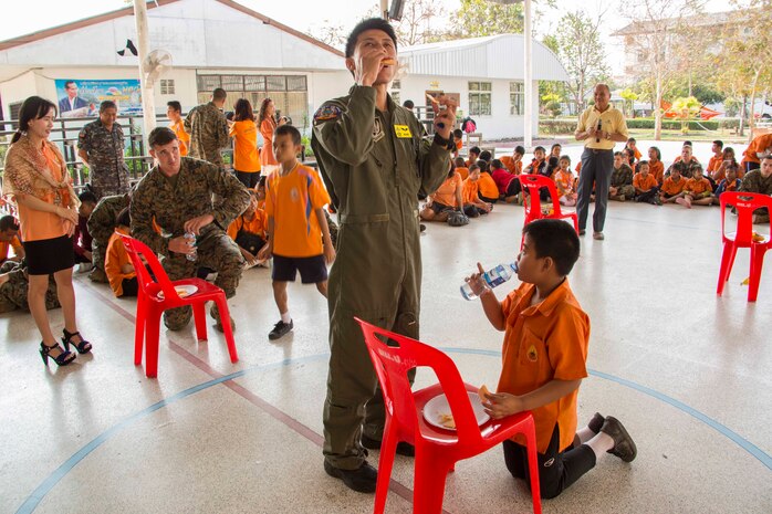 Flight Lt. Rungroj Pomwatthanamongkol, right, and Lance Cpl. Michael Bridenstine enjoy a community relations project with students from Nakhon Ratchasima Punyanukul School in Nakhon Ratchasima, Kingdom of Thailand, during a community relations event for exercise Cobra Gold 2014 Feb. 11. CG 14 is a joint, multinational exercise conducted annually in the Kingdom of Thailand aimed at enhancing and increasing multinational interoperability. Pomwatthanamongkol is a pilot with Squadron 401, Wing 4, Royal Thai Air Force. Bridenstine is a chemical, biological, radioactive, nuclear defense specialist with Marine Aircraft Group 12, 1st Marine Aircraft Wing, III Marine Expeditionary Force.