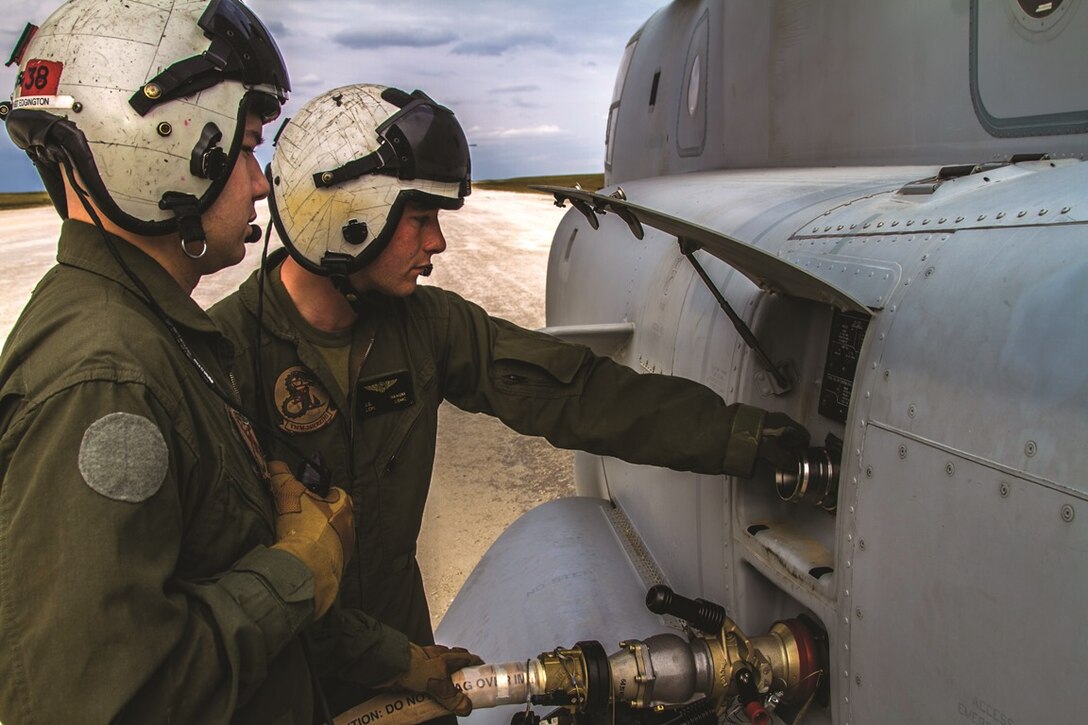Sgt. Duncan Edgington, left, and Lance Cpl. Justin Ranum observe the fuel gauge of an MV-22B Osprey during aviation delivered ground refueling operations training Feb. 5 at Ie Shima training facility. The crew chiefs of two Ospreys spent the evening familiarizing themselves with a new capability to their aircraft platform. The Marines are with Marine Medium Tiltrotor Squadron 265 (Reinforced), 31st Marine Expeditionary Unit, III Marine Expeditionary Force.