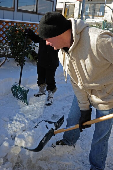 Airman 1st Class Patrick Ciccarone, 35th Fighter Wing public affairs photojournalist, shovels snow of an elderly community member’s house in Misawa City, Japan, Feb. 11, 2014.  Ciccarone is one of the five service members who volunteered to give back to the community by helping local residents in need.  (U.S. Air Force photo/Tech. Sgt. April Quintanilla)