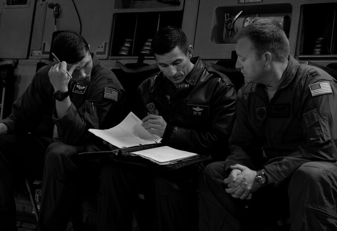 (Left to right) Capt. Aleks Layne, 17th Airlift Squadron pilot, Col. Doug Soho, 437th Operations Group chief of standards and evaluations, and Capt. Jonathan Taylor, 17th AS pilot, review documents before a flight Feb. 11, 2014, at Joint Base Charleston – Air Base, S.C. When deployed, the 17th AS will fly multiple missions every day, moving either cargo or personnel. The majority of their missions will be air drops … dropping critical supplies, such as food and ammunition to forward operating bases. (U.S. Air Force photo/Senior Airman Ashlee Galloway)