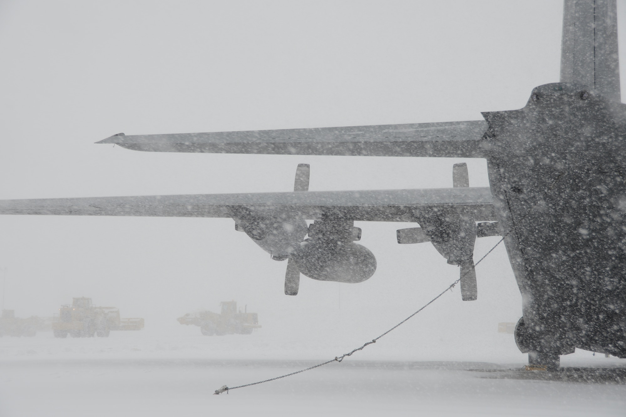 A C-130H aircraft assigned to the 103rd Airlift Wing weathers the storm during near whiteout conditions at Bradley Air National Guard Base, East Granby, Conn., as plows work to clear the flightline of the rapidly accumulating snow from a nor’easter Feb. 13, 2014. More than 200 Airmen reported to work here and at the Orange Air National Guard Station, ready to answer the call in the event the state required assistance during the height of the storm. (U.S. Air National Guard photo by Maj. Bryon M. Turner)
