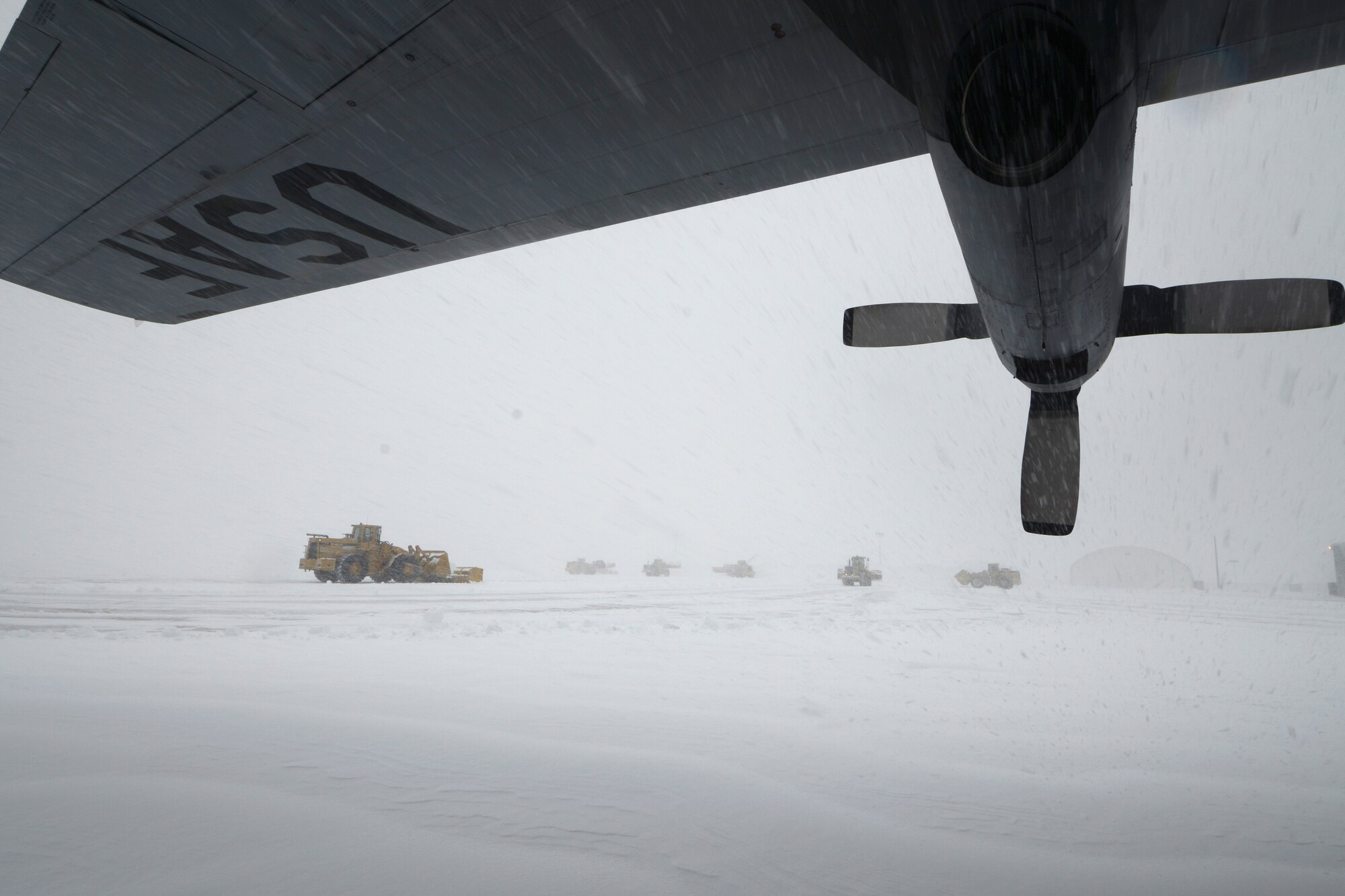 A C-130H assigned to the 103rd Airlift Wing in East Granby, Conn. weathers the storm Feb. 13, 2014, as more than a half dozen machines from the adjacent Bradley International Airport work to clear the rapdily accumulating snow from the aircraft ramp at Bradley Air National Guard Base, East Granby, Conn.  (U.S. Air National Guard photo by Master Sgt. Erin McNamara)