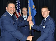 Capt. Daniel Moline, right, accepts the 302nd communications flight guideon from Col. Marty Hughes, 302nd mission support group commander, during a change of command ceremony Feb. 8, 2014. Master Sgt. Courtney Shank, first sergeant, 302nd CF, was the guideon bearer. (U.S. Air Force photo/Master Sgt. Daniel Butterfield)