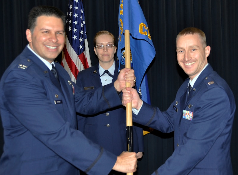 Capt. Daniel Moline, right, accepts the 302nd communications flight guideon from Col. Marty Hughes, 302nd mission support group commander, during a change of command ceremony Feb. 8, 2014. Master Sgt. Courtney Shank, first sergeant, 302nd CF, was the guideon bearer. (U.S. Air Force photo/Master Sgt. Daniel Butterfield)