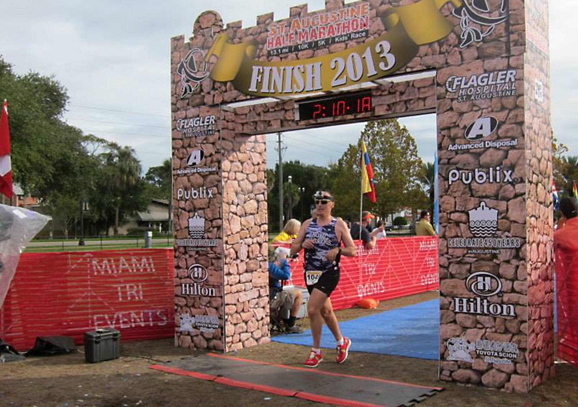 U.S. Air Force Chief Master Sgt. John Huhn, 723d Aircraft Maintenance Squadron superintendent, crosses the finish line for the St. Augustine, Fla. Half Marathon, Nov. 17, 2013. Huhn is wearing a purple camouflage ‘Road Warriors’ shirt he received from a group he joined while stationed at Scott Air Force Base, Ill. (Courtesy photo) 