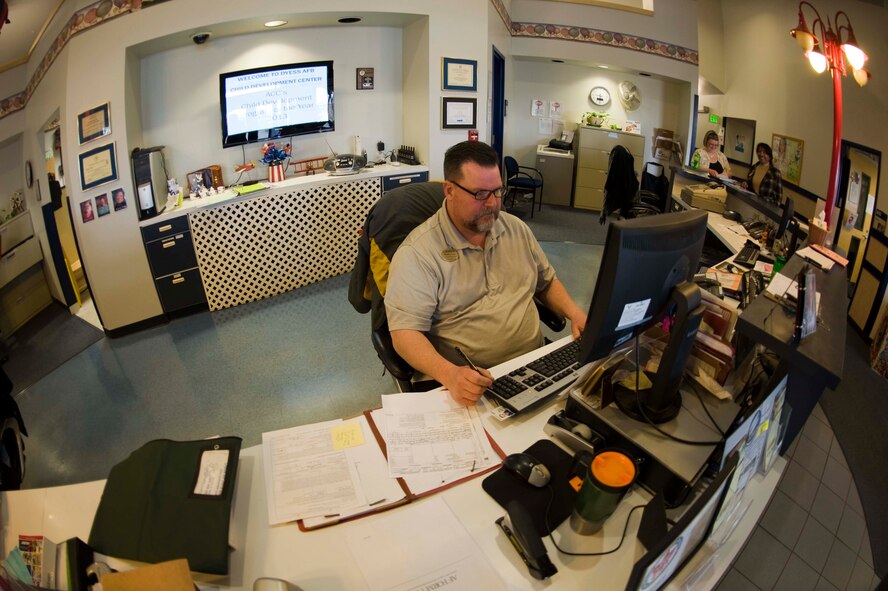 Matthew Gray, Dyess Child Development Center staff member, works at the front desk enrolling children on waiting lists and signing visitors into the CDC Feb. 5, 2014, at Dyess Air Force Base, Texas. Gray and the rest of the staff at the CDC maintain their programs and help improve each one as needed through classroom and caregiver feedbacks and surveys. (U.S. Air Force photo by Airman 1st Class Kylsee Wisseman/Released)