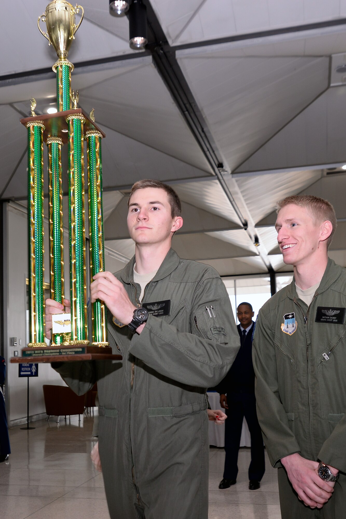 Cadets 2nd Class George Antoniou (left) and Nathan Dickey hoist the 2013 NIFA Regional Competition trophy at Mitchell Hall Feb. 12. The Academy's Flying team won the NIFA Region 1 competition for the 27th year in a row. (U.S. Air Force Photo/Liz Copan)