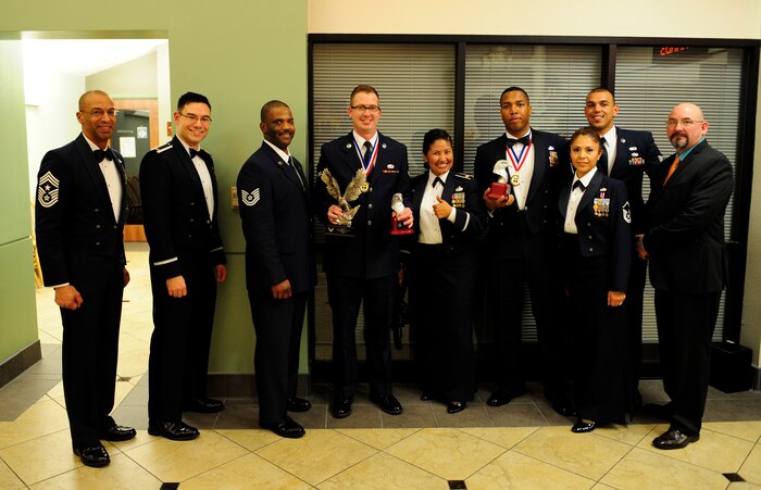 Airman First Class Kenley Lott (center), 9th Mission Support Group, holds his Volunteer of the Year awards for the 9th Reconnaissance Wing and Team Beale categories at the 2013 annual awards ceremony at Beale Air Force Base, Calif., Feb. 7, 2014. Lott is just one of many Airmen who have given back to the community through volunteering. (U.S. Air Force photo by Airman 1st Class Bobby Cummings/Released)