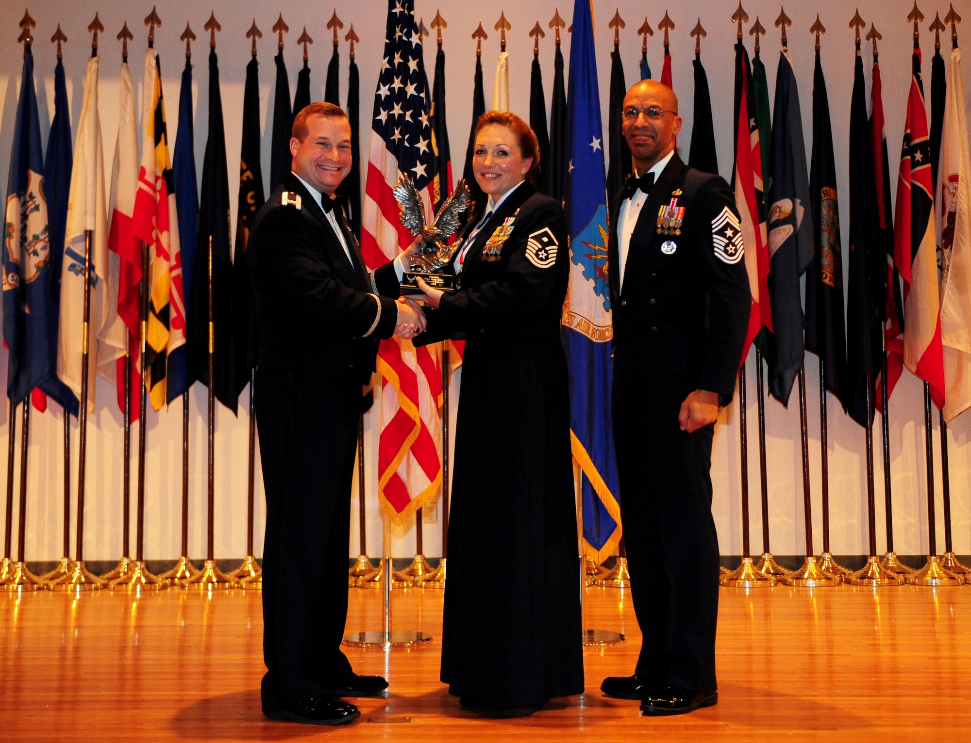 Master Sgt. Amy Riley (center), 9th Maintenance Group, is presented the award for Team Beale’s First Sergeant of the year by Col. Phil Stewart, 9th Reconnaissance Wing commander and Chief Master Sgt. Leslie Gould, 9th RW command chief, at the 2013 annual awards ceremony at Beale Air Force Base, Calif., Feb. 7, 2014. (U.S. Air Force photo by Airman 1st Class Bobby Cummings/Released)
