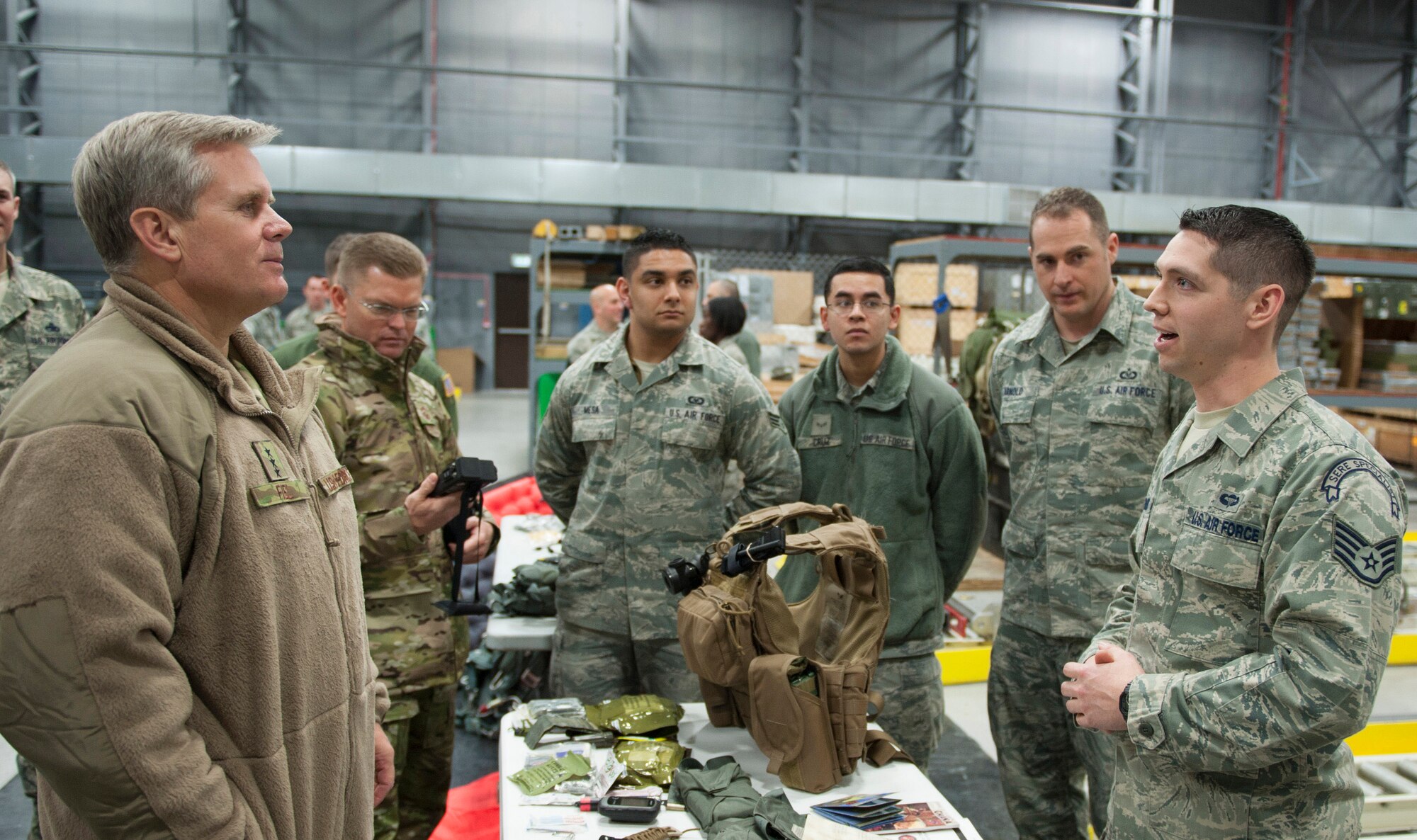 Staff Sgt. Jacob Schmidt, 352nd Special Operations Support Squadron survival, evasion, resistance and escape specialist (right), speaks to Lt. Gen. Eric Fiel, Air Force Special Operations Command commander (left),  about survival equipment Feb. 11, 2014, during the general’s visit to RAF Mildenhall, England. Fiel met with Airmen assigned to the 352nd Special Operations Group and toured different facilities used by the group. (U.S. Air Force photo by Staff Sgt. Stephen Linch)