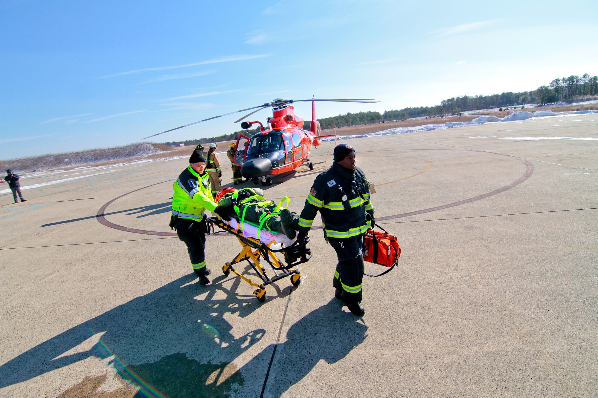 A picture of Emergency medical technicians transporting U.S. Air Force Maj. Jared Mandella on a stretcher.