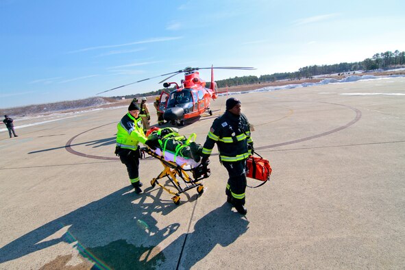 A picture of Emergency medical technicians transporting U.S. Air Force Maj. Jared Mandella on a stretcher.