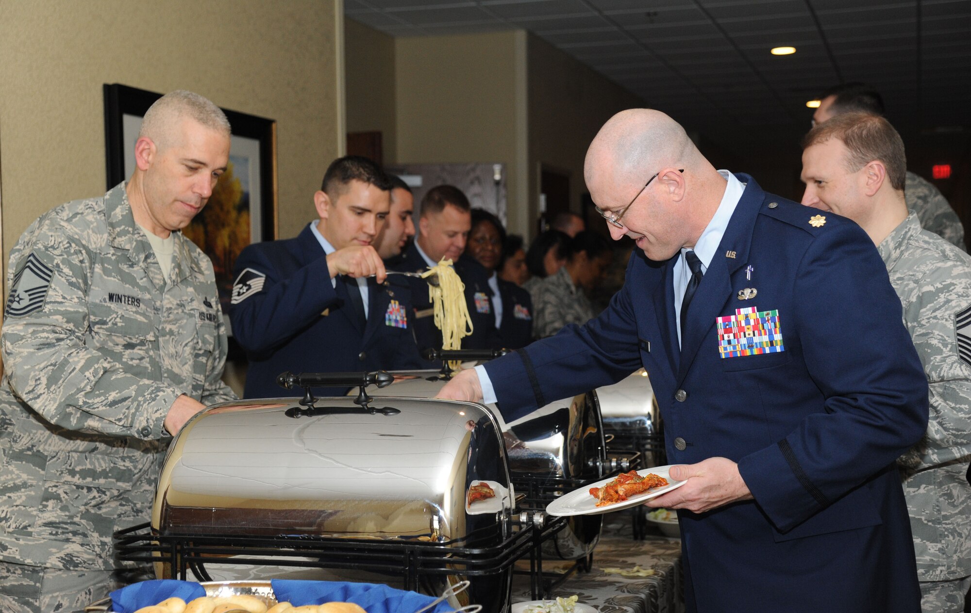 Chief Master Sgt. Robert Winters, 81st Training Group superintendent, and Chaplain (Maj.) Eugene Lahue, 81st Training Wing, help themselves to the buffet during the National Prayer Luncheon Feb. 12, 2014, at the Bay Breeze Event Center, Keesler Air Force Base, Miss.  The annual event, a tradition that stems back to President Dwight D. Eisenhower in 1953, allows individuals of different faiths and backgrounds to join together to reflect and develop their spiritual fitness. This year’s theme was “One Voice, United in Prayer.”  (U.S. Air Force photo by Kemberly Groue)