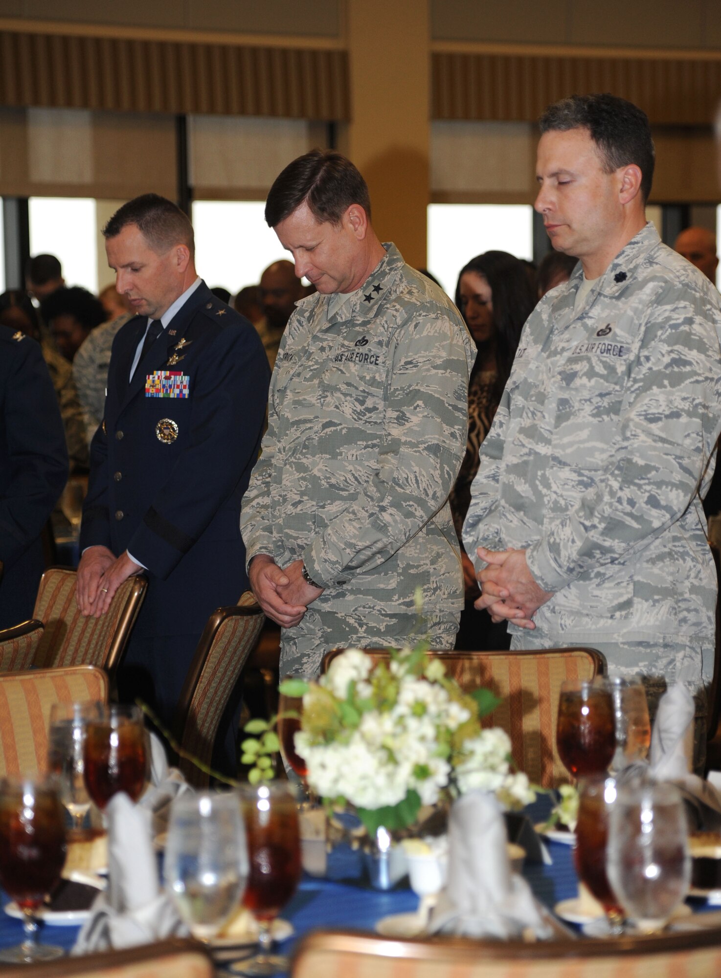 Brig. Gen. Patrick Higby, 81st Training Wing commander,; Maj. Gen. Leonard Patrick, 2nd Air Force commander, and Lt. Col. Kyle Tate, 81st Mission Support Group deputy commander, bow their heads in prayer during the National Prayer Luncheon Feb. 12, 2014, at the Bay Breeze Event Center, Keesler Air Force Base, Miss.  The annual event, a tradition that stems back to President Dwight D. Eisenhower in 1953, allows individuals of different faiths and backgrounds to join together to reflect and develop their spiritual fitness. This year’s theme was “One Voice, United in Prayer.”  (U.S. Air Force photo by Kemberly Groue)