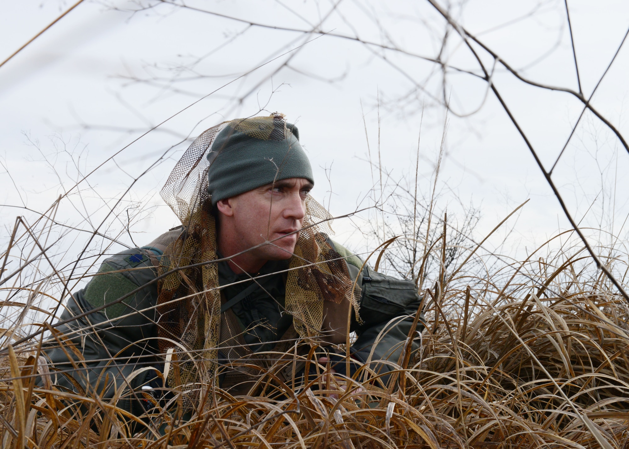 U.S. Air Force Lt. Col. Christopher Austin, 510th Fighter Squadron commander, attempts to blend into the available terrain while evading opposing forces during a simulated combat search and rescue mission, Jan. 28, 2014, at Cellina Meduna training ground near Maniago, Italy. The training allowed aircrew to practice evading capture, communicating with assets in the air and an opportunity to conduct hoist training with a U.S. Army 12th Combat Air Brigade UH-60 Black Hawk helicopter crew. (U.S. Air Force photo/Airman 1st Class Ryan Conroy) 