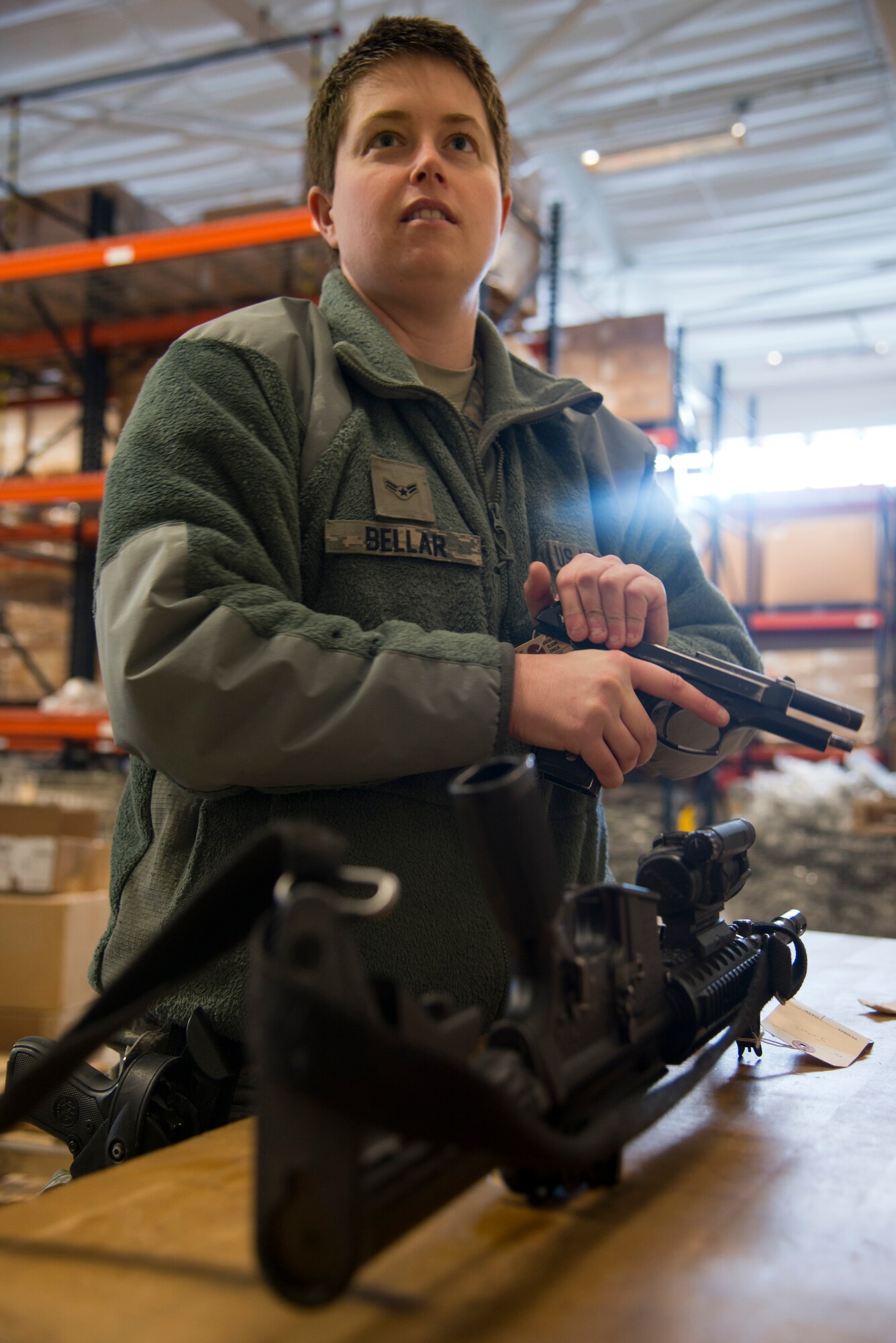 Airman 1st Class Jenae Bellar, 22nd Logistics Readiness Squadron individual protective equipment apprentice, checks the barrel of a Beretta M9 pistol Feb. 12, 2013, at McConnell Air Force Base, Kan. IPE Airmen maintain and clean weapons to make sure there is no dirt or other substances that could affect its functionality. (U.S. Air Force photo/Airman 1st Class John Linzmeier)