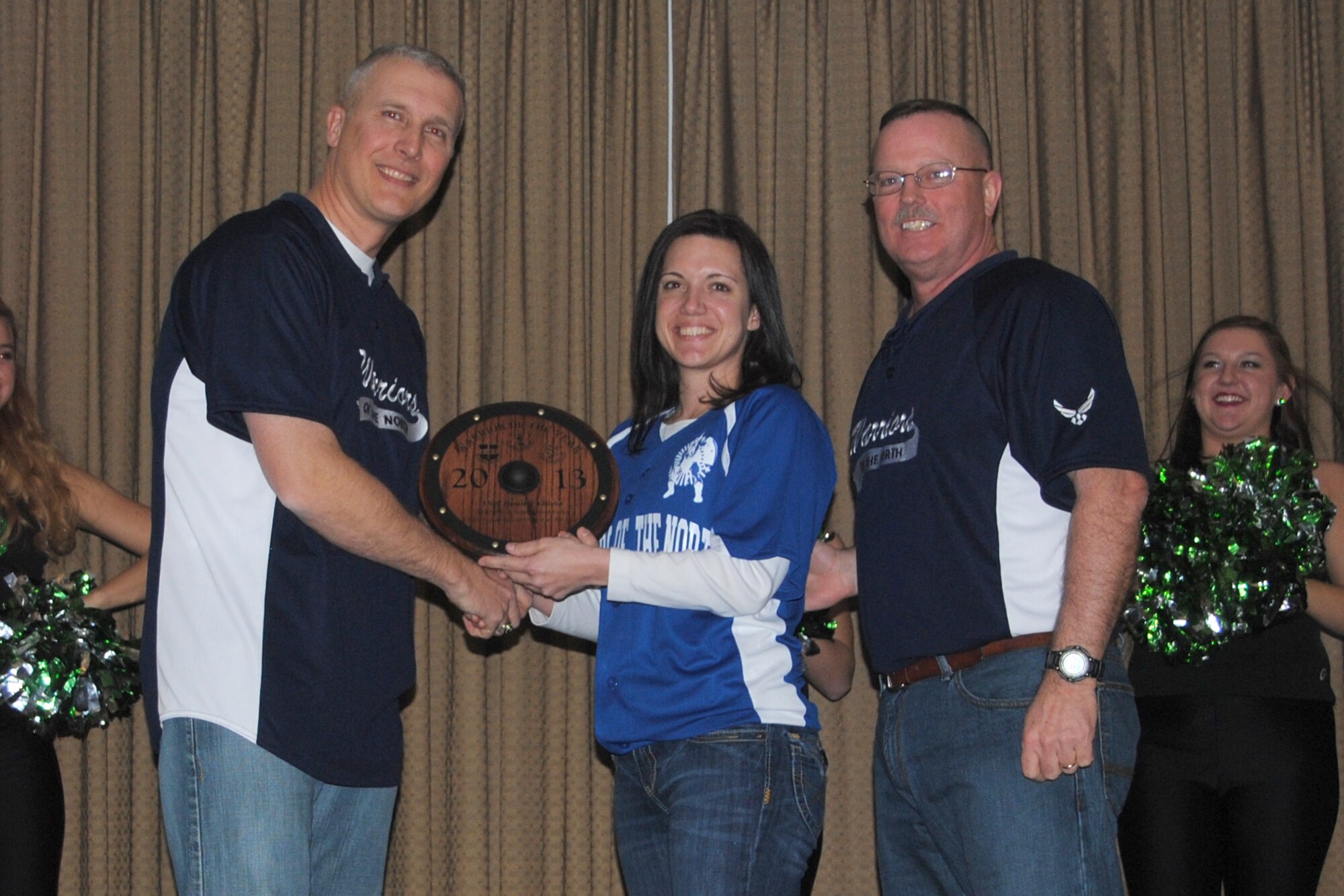 (At opposite ends) Col. Paul Bauman, 319th Air Base Wing Commander and 319th ABW command chief, Chief Master Sgt. David Duncan, present Tech. Sgt. Jennifer C. Ellison with the award for the 319th Air Base Wing and Team Grand Forks NCO of the Year category during the 2013 Grand Forks Air Force Base Annual Awards Feb. 7, 2014, at the Northern Lights Club on Grand Forks AFB, N.D. The winners received small Viking-style shields. (U.S. Air Force photo/Staff Sgt. Luis Loza Gutierrez) 