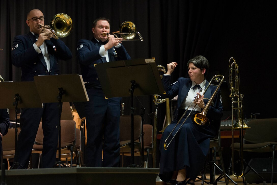 U.S. Air Forces in Europe Band brass ensemble trombone players U.S. Air Force Airman 1st Class Ben Huseby from Powers Lake, N.D., left, and Staff Sgt. John Marsh from Columbus, Ohio, center, play their instruments while U.S. Air Force Tech. Sgt. Saundra Sininger, USAFE Band brass ensemble trombone player from Williamstown, Ky., looks on during a performance at Mehrzweckhalle in Kenn, Germany, Feb. 11, 2014. The Brass ensemble consists of 11 brass players, two percussionists and one vocalist. (U.S. Air Force photo by Staff Sgt. Christopher Ruano/Released)