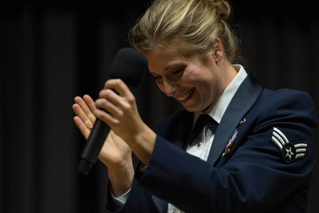 U.S. Air Force Senior Airman Carmen Emborski, U.S. Air Forces in Europe Band brass ensemble vocalist from Colorado Springs, Colo., claps during a performance at Mehrzweckhalle in Kenn, Germany, Feb. 11, 2014. The USAFE Band, stationed at Ramstein Air Base, Germany, brings the military tradition of brass and percussion to a wide variety of concert settings across Europe. (U.S. Air Force photo by Staff Sgt. Christopher Ruano/Released)