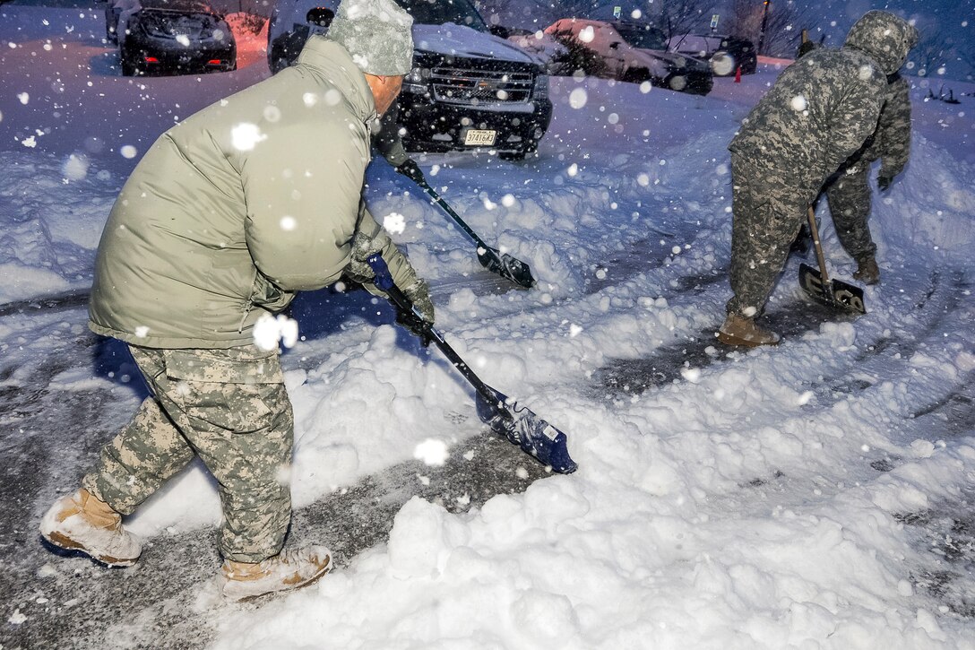 Soldiers shovel snow before preparing their vehicles and equipment on Camp Fretterd Military Reservation near Reisterstown, Md., Feb. 13, 2014, to help first responders during a declared state of emergency.