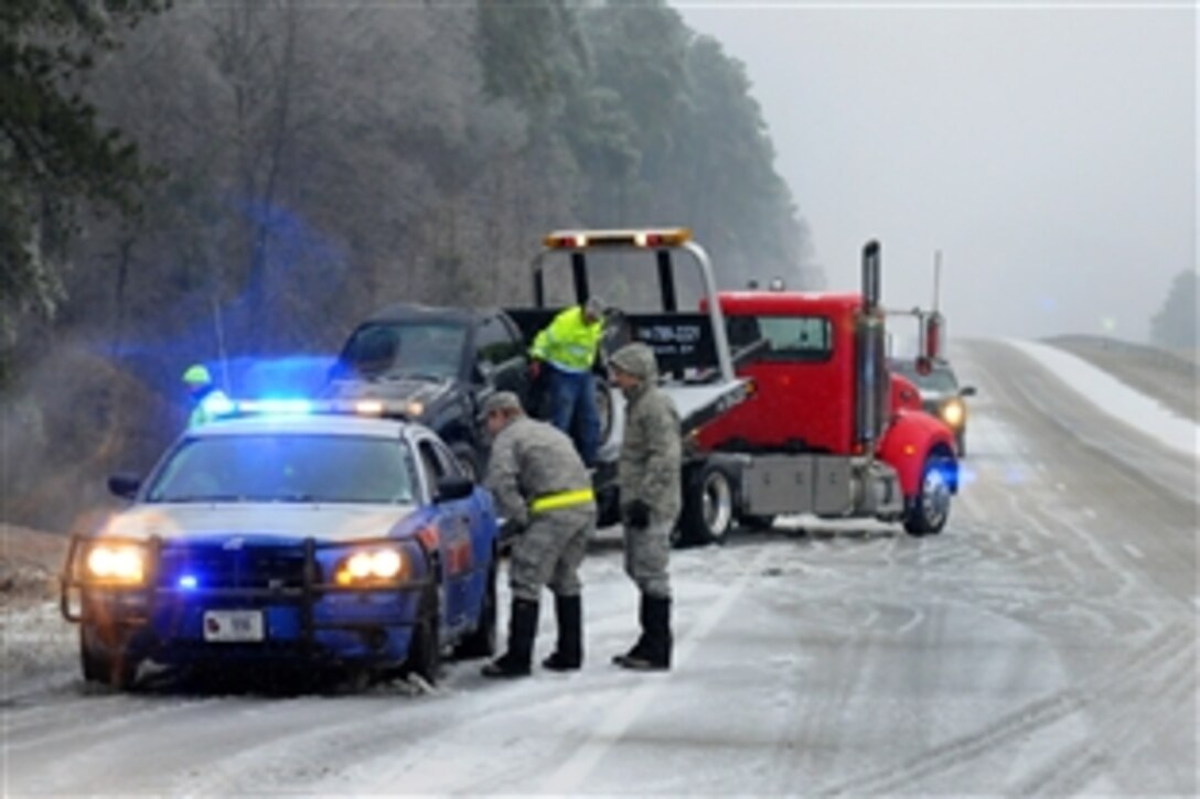 Air Force Maj. Nicholas Anthony, left, speaks with a Georgia State Patrol officer at the scene recovering a vehicle that slid off the road along Interstate 20 while providing emergency service and support to civil authorities and to residents during a winter storm, Augusta, Ga., Feb. 12, 2014. Anthony is a flight commander for Georgia National Guard's 165th Air Support Operations Squadron, Savannah, Ga.