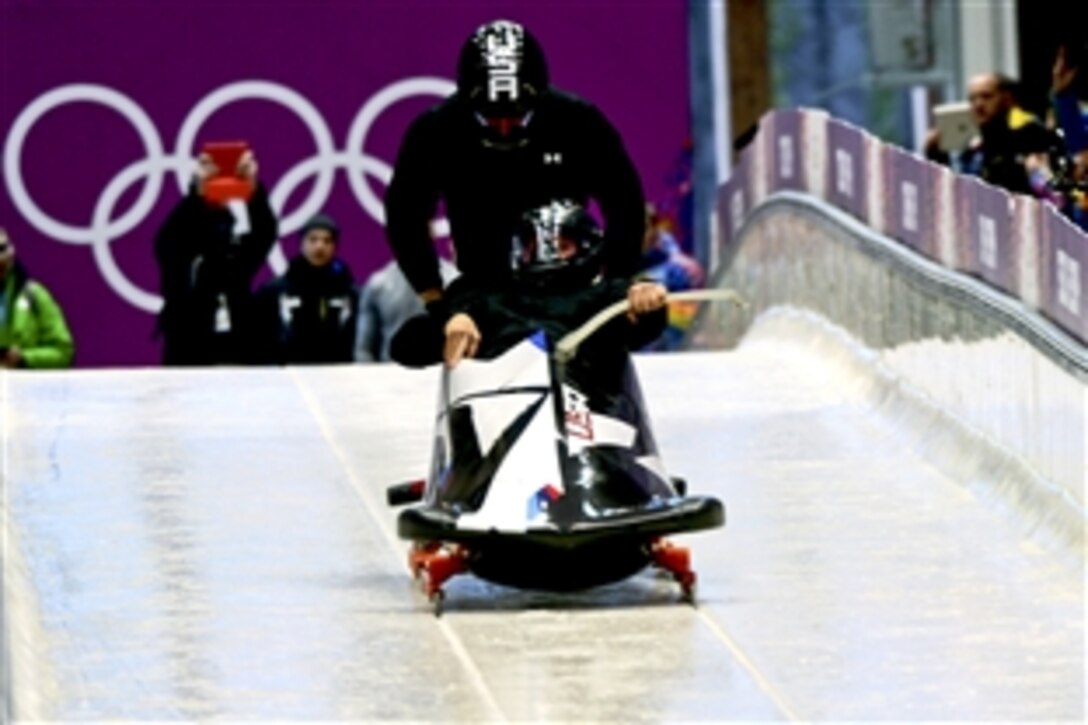 U.S. Army Capt. Chris Fogt, top, a bobsled brakeman, pushes Steven Holcomb to the sixth-fastest time among 30 sleds in Olympic two-man bobsled training at Sanki Sliding Centre in Krasnaya Polyana, Russia, Feb.13, 2014. The U.S. duo was clocked at 81.4 mph with a time of 56.98 seconds. Fogt is assigned to the U.S. Army World Class Athlete Program, and Holcomb, a 2010 Olympic gold medal winner as a four-man bobsled driver, is a former program teammate and former Utah National Guardsman.