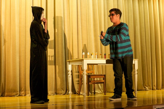 Chancellor Gardiner, left, and Koudai Franklin reenact Bobby Kenistan’s “Death and Pez,” a duet, at the M.C Perry Elementary School Gymnasium aboard Marine Corps Air Station Iwakuni, Japan, Feb. 8, 2014, as a rehearsal for the 2014 Far East Drama Festival. Gardiner plays Death and Franklin plays Reggie. In this scene, Reggie attempts to negotiate with Death to extend his life for six more months to experience new things in life. The 2014 Far East Drama Festival consists of 13 Department of Defense Education Activity Pacific schools where students present their performance in a one act play with all cast members participating, followed by two individual events being either a monologue, a duet, or a trio scene.  