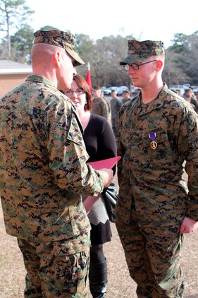 Sgt. Jeremy Moses (right), a motor transportation operator with Transportation and Support Company, Combat Logistics Battalion 2, 2nd Marine Logistics Group, and his wife stand in front of Lt. Col. William Stophel, the commanding officer of CLB-2, during a Purple Heart Medal ceremony aboard Camp Lejeune, N.C., Feb. 7, 2014. Three Marines with the company were awarded the Purple Heart for wounds suffered in action while deployed in support of Operation Enduring Freedom. 