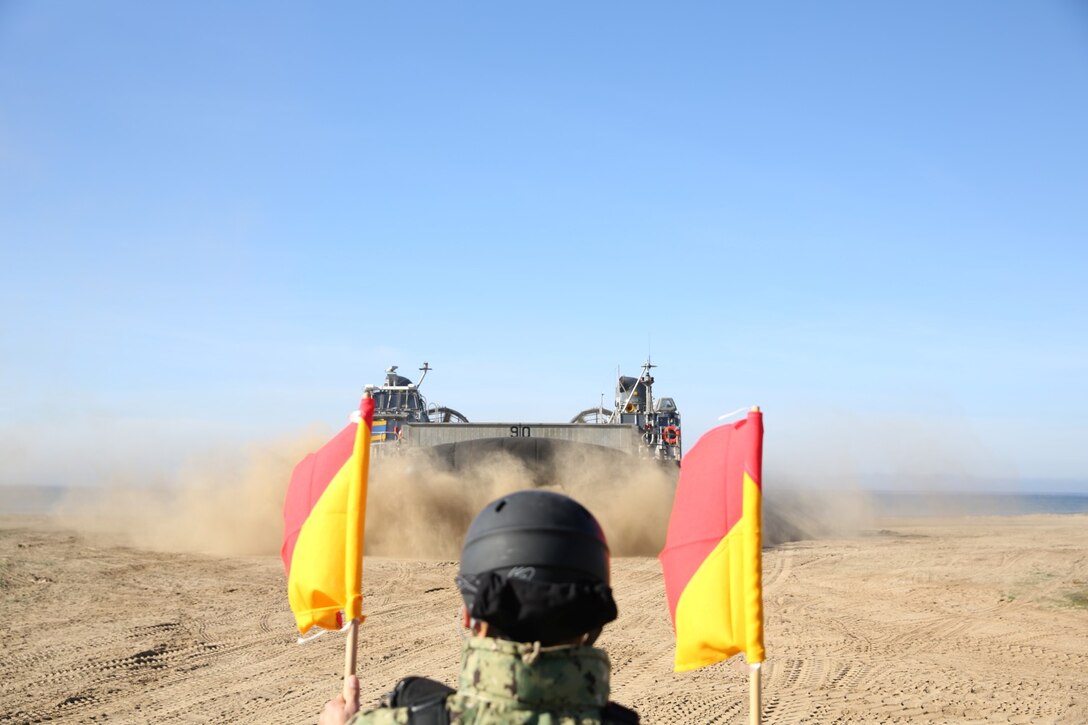 Petty Officer 3rd Class Bryan Dingess, boatswain's mate, Beach Master Unit 1, guides a Landing Craft Air Cushion onto the beach during Exercise Iron Fist 2014 aboard Camp Pendleton, Calif., Feb. 12, 2014. Iron Fist is an amphibious exercise that brings together Marines and sailors from the 15th Marine Expeditionary Unit, other I Marine Expeditionary Force units, and soldiers from the JGSDF, to promote military interoperability and hone individual and small-unit skills through challenging, complex and realistic training. (U.S. Marine Corps photo by Lance Cpl. Ricardo Hurtado/Released)