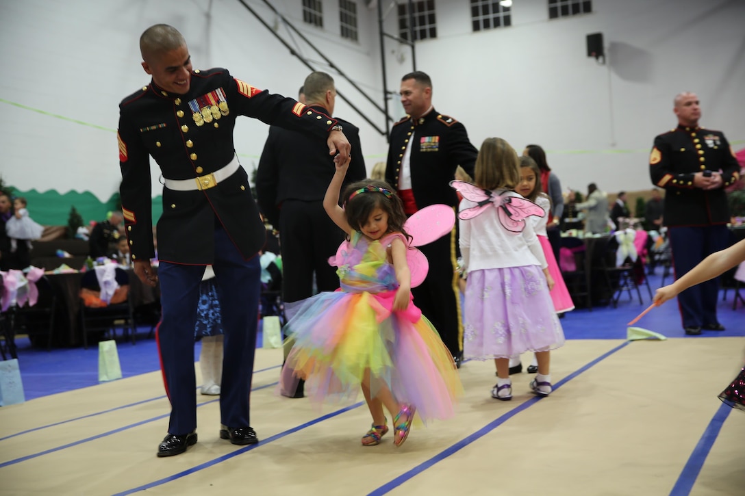 A Marine in his dress blue uniform, dances with his daughter during the 7th Annual Father-Daughter Dance aboard the depot, Jan. 31. The dance theme was an enchanted fairy forest. 
