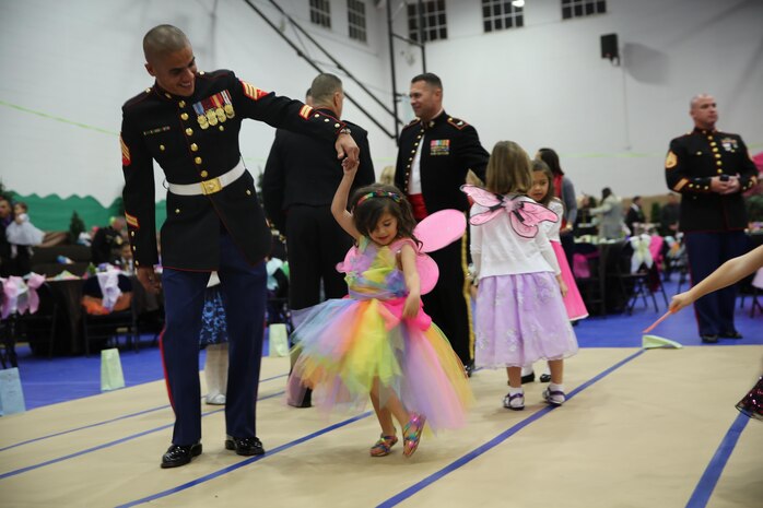 A Marine in his dress blue uniform, dances with his daughter during the 7th Annual Father-Daughter Dance aboard the depot, Jan. 31. The dance theme was an enchanted fairy forest. 