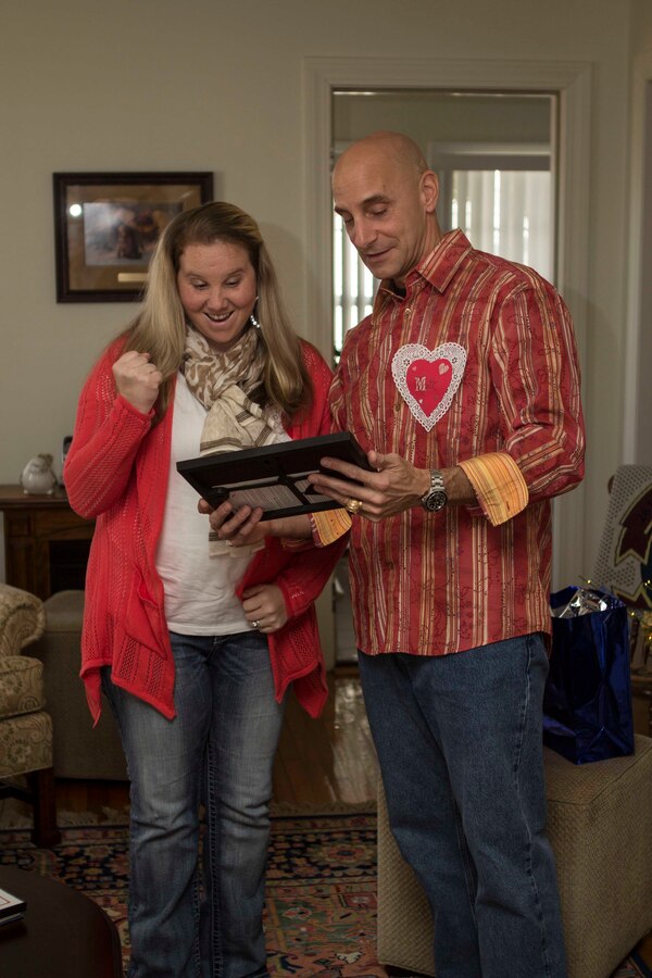 Col. Matthew G. St. Clair, 26th Marine Expeditionary Unit (MEU) commanding officer, presents a plaque of recognition to a volunteer during a get together to recognize efforts of family readiness volunteers, the link between deployed Marines, spouses and children left behind during the 26th MEU's latest deployment, Feb. 7, 2014. (U.S. Marine Corps photo by Cpl. Michael S. Lockett/Released)