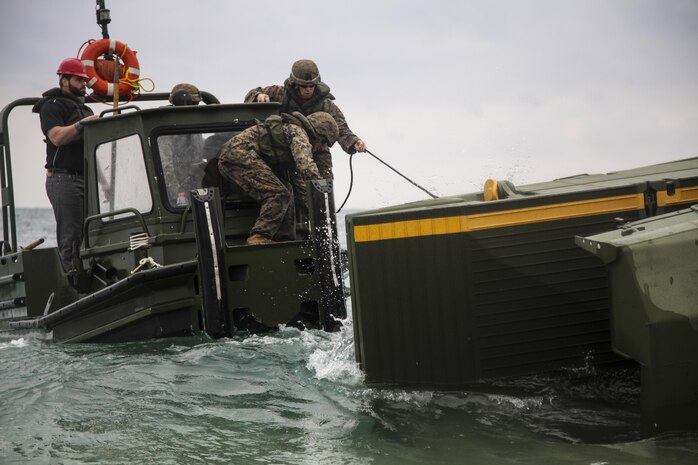 Marines battle heavy seas Feb. 7 to assemble an Improved Ribbon Bridge during new equipment training at Camp Schwab. The IRB consists of two components, a ramp bay, which forms the end of the bridge, and the interior bay, forming the center. The Marines are with 9th Engineer Support Group, 3rd Marine Logistics Group, III Marine Expeditionary Force.