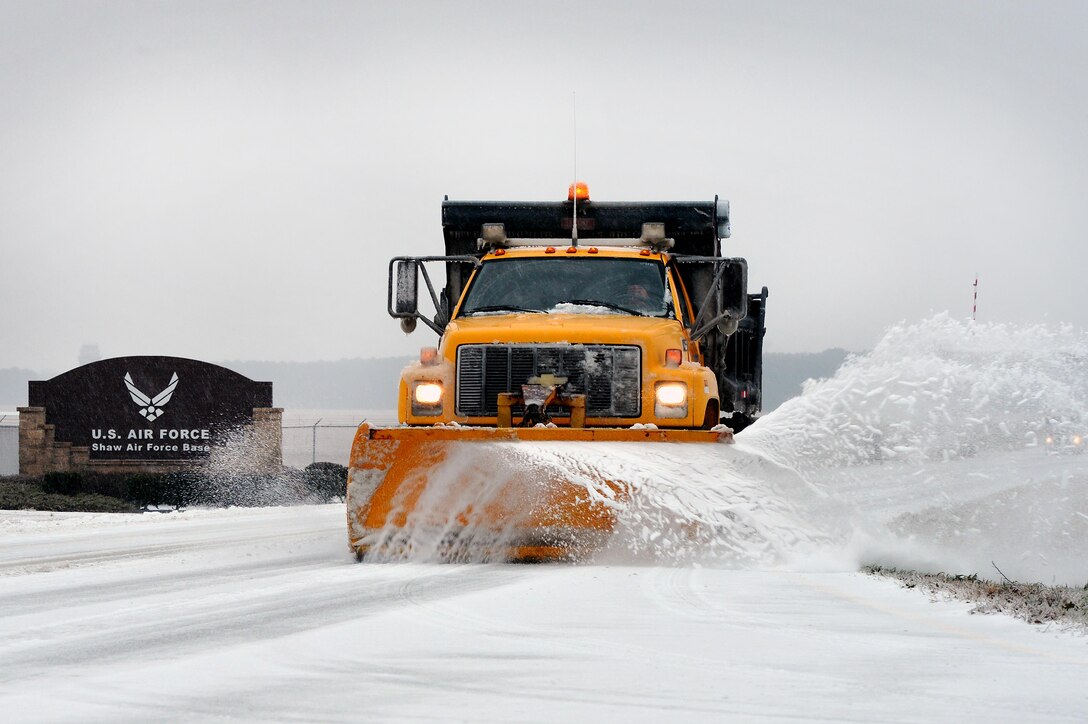 A snow plow removes snow and ice outside the base main gate Feb. 12, 2014, at Shaw Air Force Base, S.C. Though severe winter weather is rare at Shaw AFB, this winter season has presented a fair amount of snow, sleet and ice. More than once this season, base officials had to reduce manning to mission essential personnel due to inclement weather. (U.S. Air Force photo/Staff Sgt. Kenny Holston)