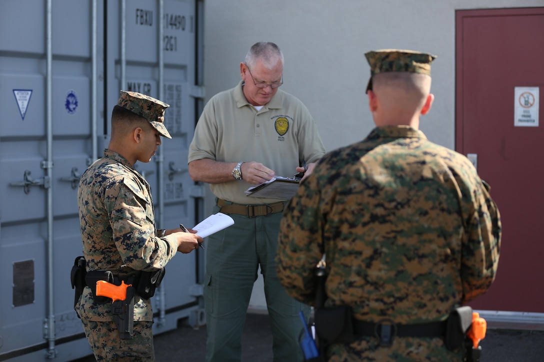 Mark Murphy, an instructor at the Marine Corps Police Academy West, leads two Marines in an evidence-gathering exercise aboard Marine Corps Air Station Miramar, Calif., Feb. 11. Marines that attend the academy are already military police and attend for follow-on training.