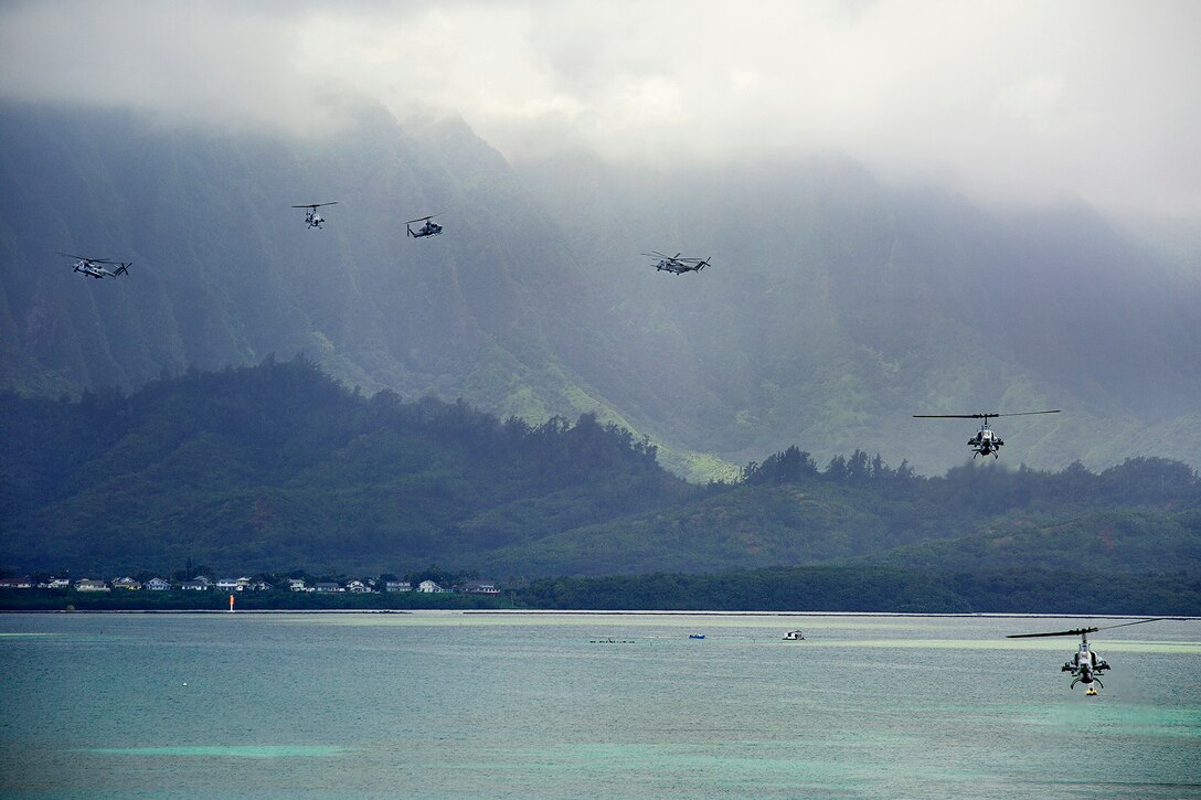 UH-1Y Huey, AH-1W Cobra and CH-53E Super Stallion helicopters prepare to land on the flight line at Marine Corps Air Station Kaneohe Bay, Feb. 13, 2014. Marine Aircraft Group 24 conducted a max launch of 13 helicopters assigned to Marine Light Attack Helicopter Squadron 367 and Marine Heavy Helicopter Squadron 463. The two units coordinated with each other to fly the aircraft to Kauai, Hawaii before returning to Oahu. “While HMLA-367 and HMH-463 are flying, (Marine Wing Support Detachment 24) and (Marine Aviation Logistics Squadron 24) will be on the ground to provide forward arming and refueling points,” said Maj. Jeff Marantette, a future operations officer with MAG-24. “It gives the MAG a chance to work as a whole and show how we operate, because that doesn’t happen very often.” After refueling at Dillingham Airfield, the aircraft completed their max launch with a flyby over Marine Corps Base Hawaii before landing. (U.S. Marine Corps photo by Lance Cpl. Matthew Bragg)