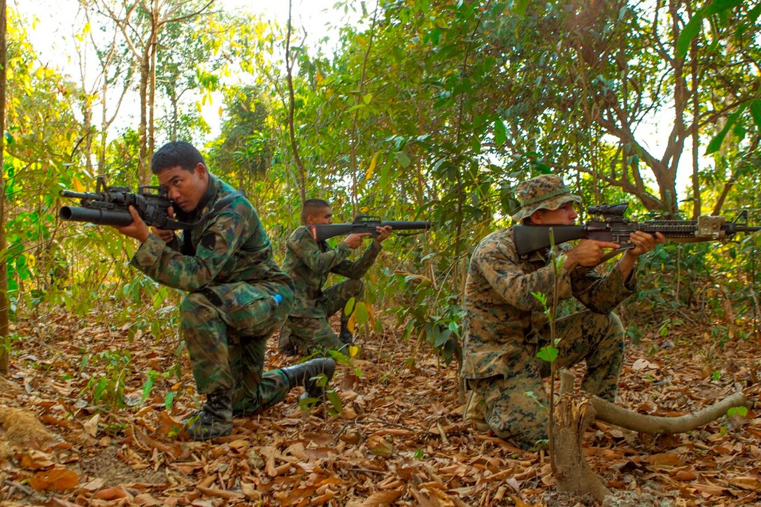 Royal Thai Marine Petty Officer 2nd Class Poramet Panpach, left, Seaman Somchok Mangkou, center, and U.S. Marine Lance Cpl. Beto A. Chavarria kneel to provide a 360 degree security perimeter Feb. 12 at Ban Chan Krem, Kingdom of Thailand. The U.S. Marines and Royal Thai Marines are currently taking part in Exercise Cobra Gold, which is a multinational and multiservice exercise that takes place annually in the Kingdom of Thailand and was developed by the Thai and U.S. militaries. The day's training evolution consisted of Royal Thai Marines and U.S. Marines practicing various jungle patrolling tactics, techniques and procedures. Panpach and Mangkou are both basic infantrymen with 3rd Small Arms Company, 7th Battalion, 3rd Regiment, of the Marine Division. Chavarria is a rifleman with Lima Company, 3rd Battalion, 1st Marine Regiment, which is currently attached to 4th Marines, 3rd Marine Division, III Marine Expeditionary Force, as part of the Marine Corps' unit deployment program.