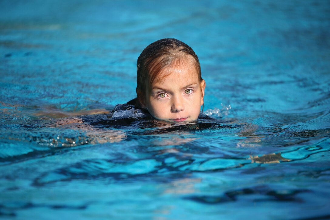 Nola Rivaldi, 7, pops out of the water after practicing a dive during a springboard diving class, Feb. 12, 2014 at the Marine Corps Base Hawaii pool. The class is available to children ages 7 to 13. (U.S. Marine Corps photo by Cpl. Sarah Dietz)