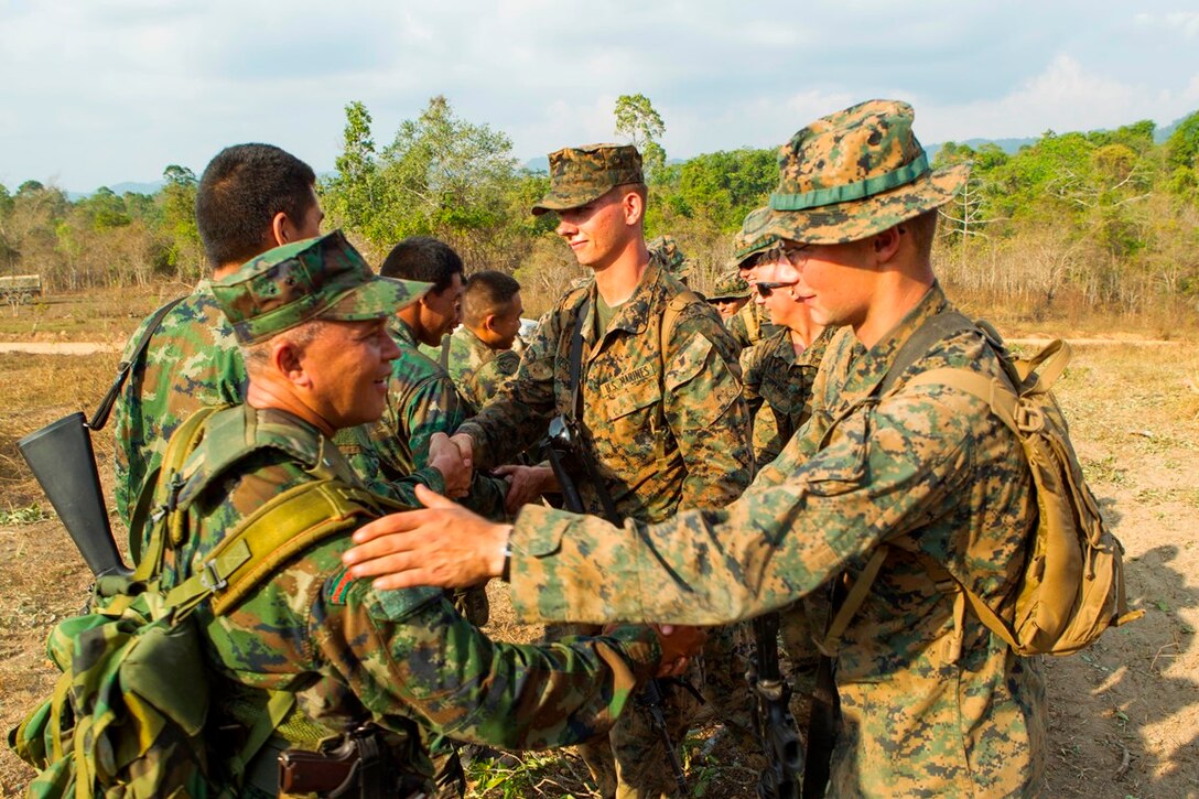 Royal Thai Marine Capt. Jirapan Sukpimai, left, shakes hands with U.S. Marine Lance Cpl. James P. Soccodato Feb. 12 after a full day of jungle patrolling training at Ban Chan Krem, Kingdom of Thailand. Royal Thai Marines and U.S. Marines are currently taking part in Exercise Cobra Gold, which is a multinational and multiservice exercise that takes place annually in the Kingdom of Thailand and was developed by the Thai and U.S. militaries. The day's training consisted of Royal Thai Marines and U.S. Marines practicing various jungle patrolling tactics, techniques and procedures. Sukpimai is the company commander of 3rd Small Arms Company, 7th Battalion, 3rd Regiment, of the Marine Division. Soccodato is a tactical switching operator with Combat Logistics Battalion 4, Combat Logistics Regiment 3, 3rd Marine Logistics Group, III Marine Expeditionary Force.