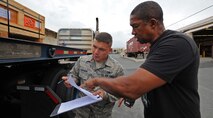 Airman First Class Erik Chapman, 647th Logistics Readiness Squadron vehicle operator, left and Walter Simmons, 647th LRS Travel Management Office Outbound Section, verify the manifest for cargo after loading it aboard a 40-foot flatbed trailer at the 647th Travel Management Office on Joint Base Pearl Harbor-Hickam, Hawaii, Feb. 14, 2014. On an annual basis, the 647th LRS moves more than 19,000 passengers, 7,294 short tons of cargo, 2,500 personal property shipments, and processes an excess of 215,000 supply transactions. (U.S. Air Force photo/Master Sgt. Jerome S. Tayborn)
