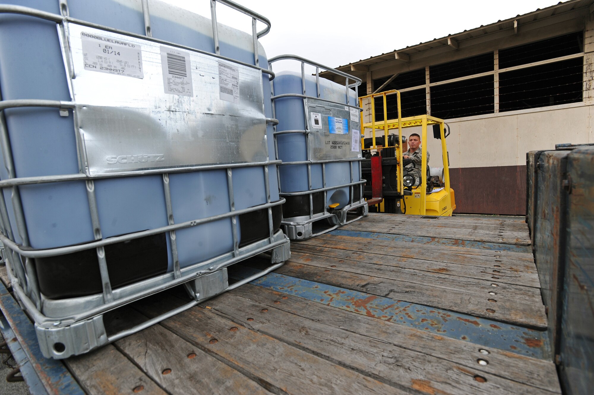 Airman First Class Erik Chapman, 647th Logistics Readiness Squadron vehicle operator, loads cargo aboard a 40-foot flatbed trailer at the 647th Travel Management Office on Joint Base Pearl Harbor-Hickam, Hawaii, Feb. 14, 2014. The 647th LRS provides logistical management and support to JBPHH, the 15th Wing, Headquarters Pacific Air Command and more than 140 associate organizations. (U.S. Air Force photo/Master Sgt. Jerome S. Tayborn)