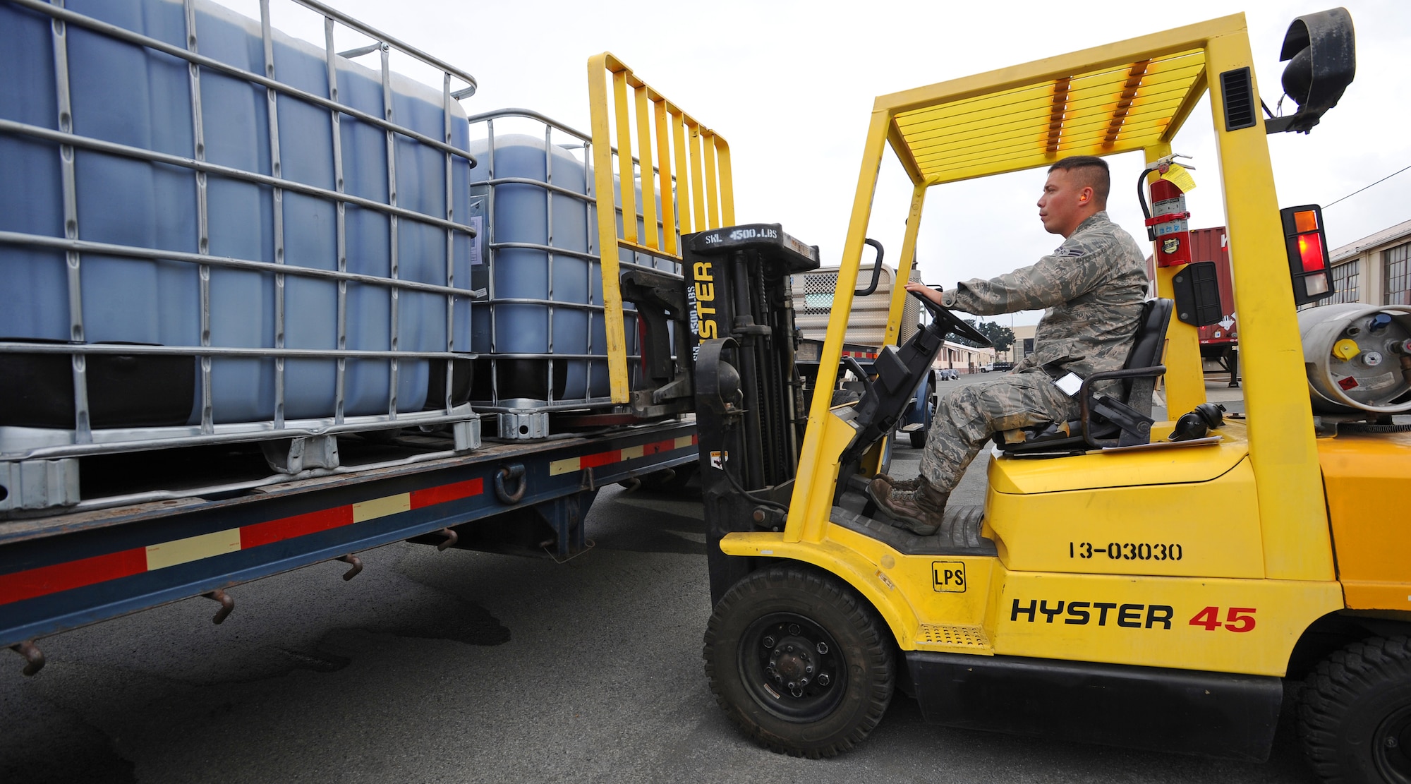 Airman First Class Erik Chapman, 647th Logistics Readiness Squadron vehicle operator, loads cargo aboard a 40-foot flatbed trailer at the 647th Travel Management Office on Joint Base Pearl Harbor-Hickam, Hawaii, Feb. 14, 2014. For authorized personnel to move cargo they first must have 40 or more hours in training before becoming certified. (U.S. Air Force photo/Master Sgt. Jerome S. Tayborn)
