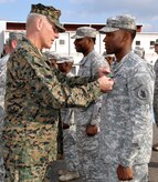 U.S. Marine Corps Gen. John F. Kelly, commander, U.S. Southern Command, presents the Army Commendation Medal to U.S. Army Sgt. Randy McKire during a Joint Task Force-Bravo promotion and awards ceremony conducted on the flightline at Soto Cano Air Base, Honduras, Feb. 13, 2014. Kelly pinned new rank on six Task Force members who were promoted during the ceremony and presented medals, including the Army Commendation Medal, the Air Force Commendation Medal, and the Army Achievement Medal, to 18 members. Following the ceremony, Kelly addressed the members of the Task Force and thanked them for their work and dedication to duty. (U.S. Air Force photo by Capt. Zach Anderson)

