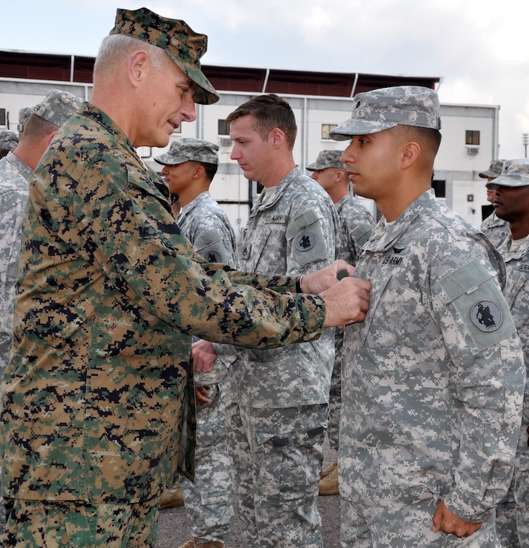 U.S. Marine Corps Gen. John F. Kelly, commander, U.S. Southern Command, pins rank on newly promoted U.S. Army Sgt. Alejandro Arellano during a promotion and awards ceremony conducted on the flightline at Soto Cano Air Base, Honduras, Feb. 13, 2014. Kelly pinned new rank on six Task Force members who were promoted during the ceremony and presented medals, including the Army Commendation Medal, the Air Force Commendation Medal, and the Army Achievement Medal, to 18 members. Following the ceremony, Kelly addressed the members of the Task Force and thanked them for their work and dedication to duty. (U.S. Air Force photo by Capt. Zach Anderson)

