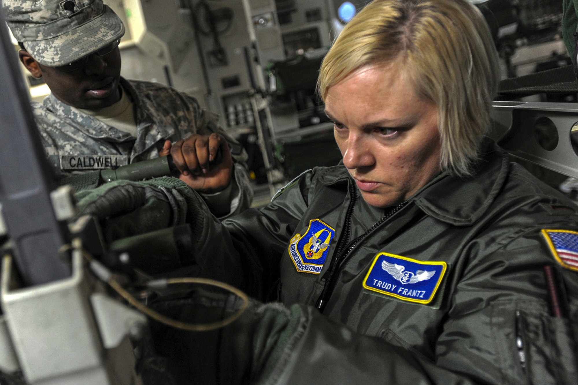 Capt. (2nd Lt.) Trudy Frantz, 446th Aeromedical Evacuation Squadron flight nurse, assembles a litter with a Soldier onboard a McChord Field C-17 Globemaster III during a mass casualty exercise. Reservists with the 446th AES trained alongside Army medical personnel during the exercise. (U.S. Army photo by Ingrid Barrentine)