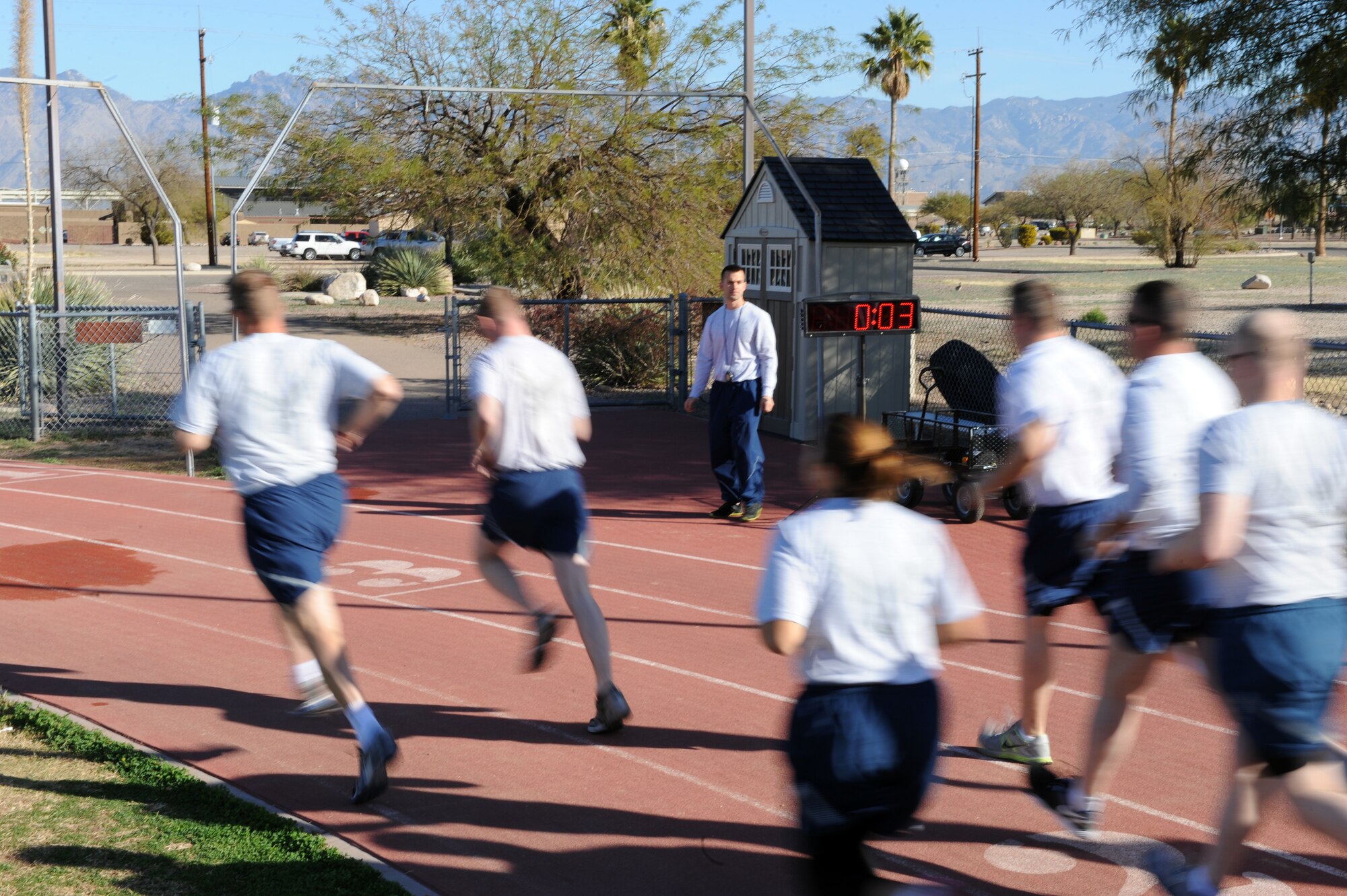 U.S. Air Force Staff Sgt. Justin Post, 355th Aircraft Maintenance Squadron, A-10 crew chief, starts the clock for the 1 1/2 mile run during a fitness assessment test at Davis-Monthan Air Force Base, Ariz., Feb. 11, 2014. Fitness tests are typically held twice per day Monday-Friday at 6:30 and 8:30 a.m. (U.S. Air Force photo by Airman 1st Class Chris Drzazgowski/Released)