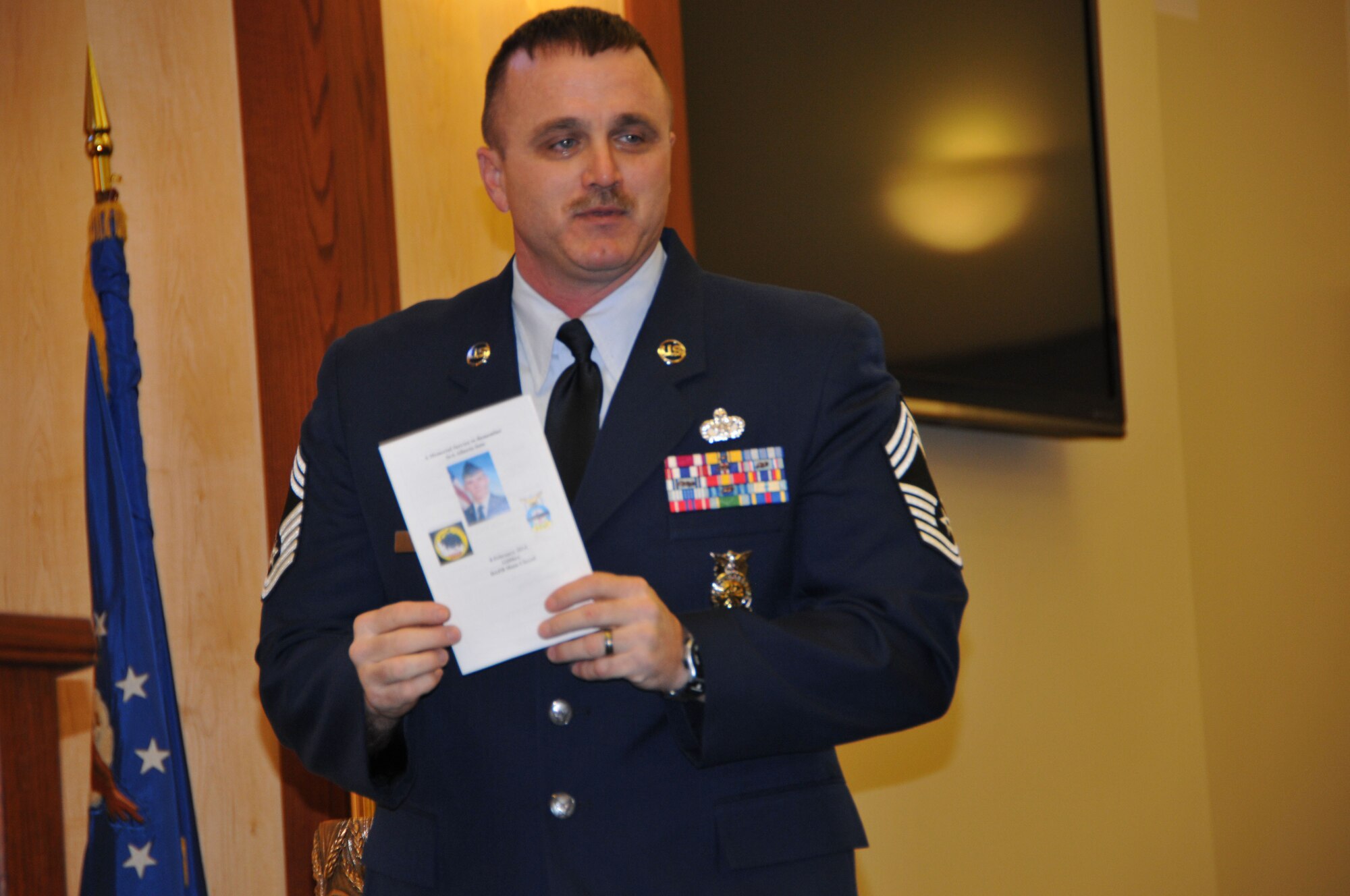 Chief Master Sgt. Brian Cullen, 512th Civil Engineer Squadron operations chief, holds a picture of Senior Airman Alberto Soto during a memorial service for Soto Feb. 8, 2014, on Dover Air Force Base, Del. Cullen praised Soto, a firefighter with the 512th CES, for his determination during upgrade training. (U.S. Air Force photo/Senior Airman Joe Yanik)